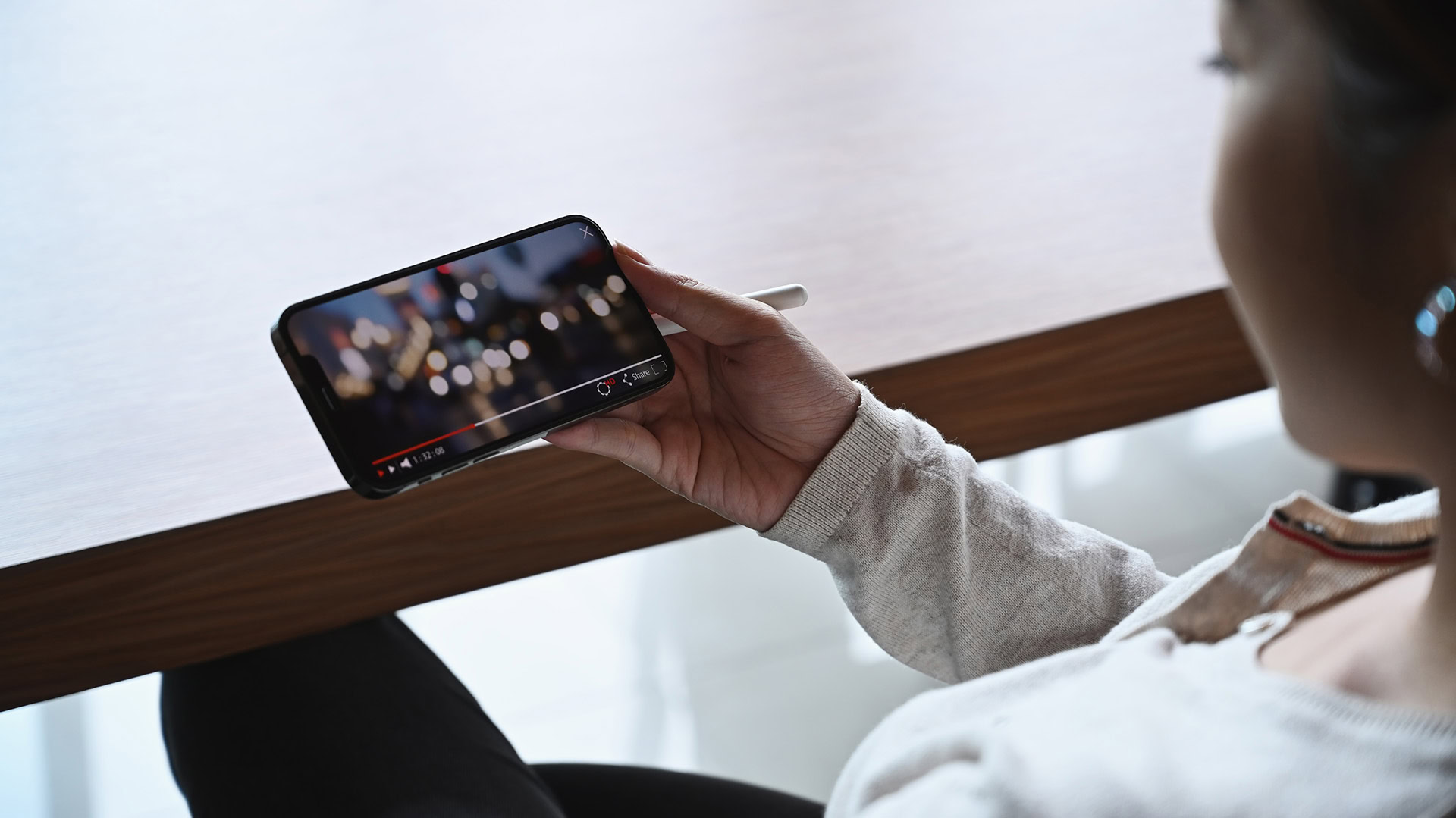 Frau, die auf ihrem Handy ein Video anschaut.